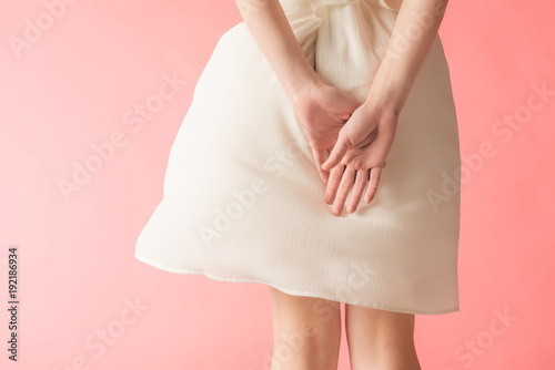 midsection view of woman posing in elegant white dress  isolated on pink