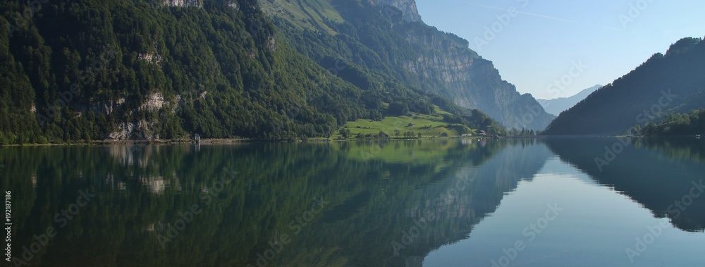 Summer scene at lake Klontalersee, Glarus Canton. Swiss Alps. Reflection.
