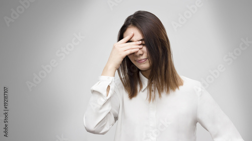 Indoor portrait of disappointed young asian woman covering her face with hands. Emotions, feelings, lifestyle concept.