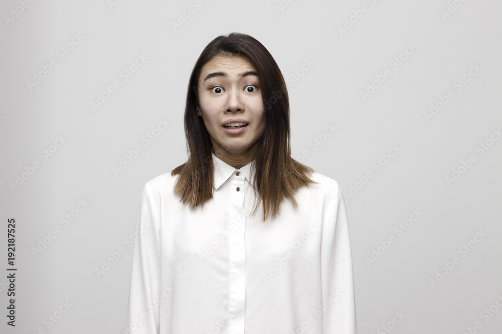 Indoor shot of shocked elegant woman in formal style looks with wide eyed expression being horrified to find out something bad, wonders how it happened. Shocking news Indoor shot of shocked elegant woman in formal style looks with wide eyed expression being horrified to find out something bad, wonders how it happened. Shocking news