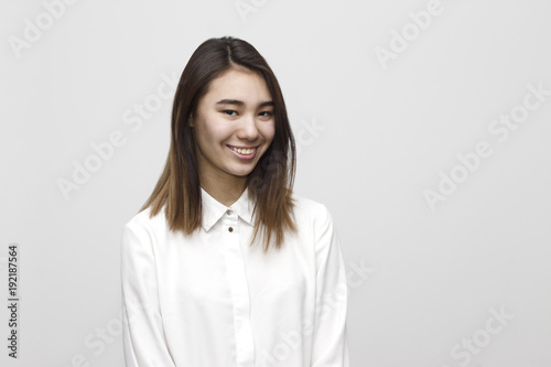 Indoor portrait of young attractive and happy woman smiling in white formal shirt on the white background. Emotions, feelings, lifestyle concept
