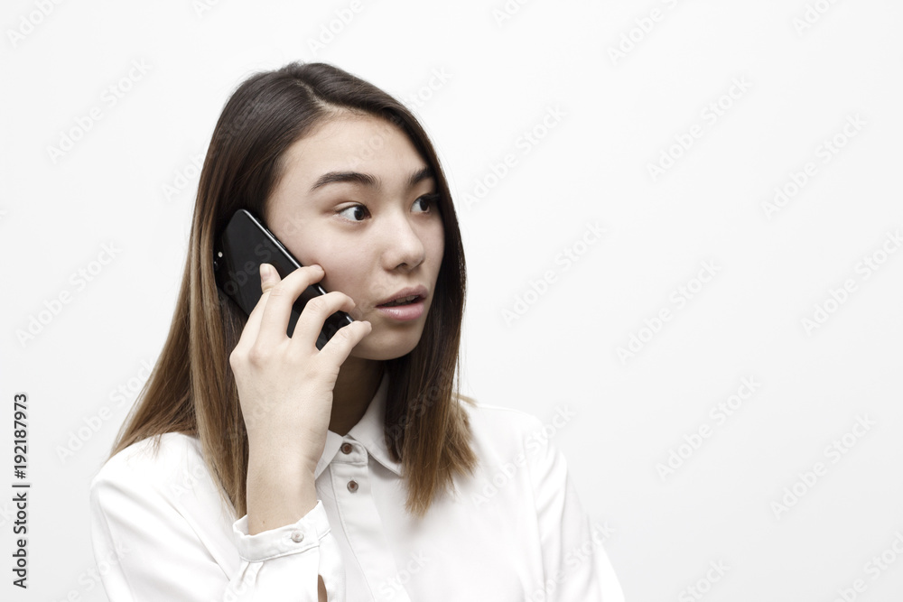 Attractive young woman talking on the phone looking away and looking shocked. Unexpected news concept. Attractive young woman talking on the phone looking away and looking shocked. Unexpected news concept.