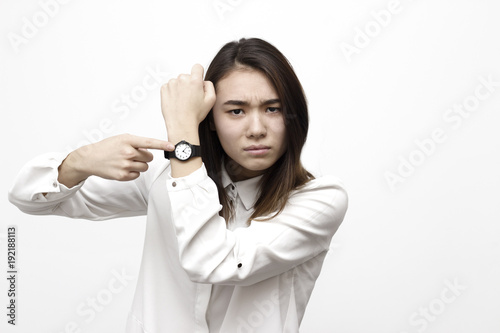 Portrait of pretty angry disappointed woman with wrist watch showing and remiding about time. Hurry up pointing on watch concept photo