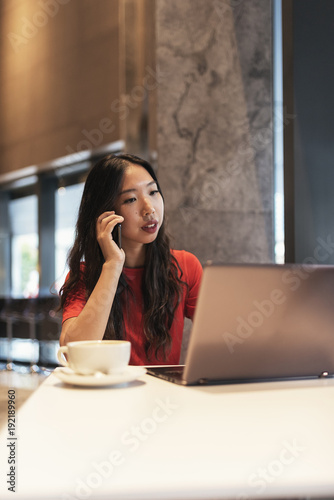 Pretty businesswoman working in coffee shop.