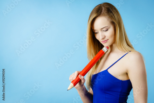 Woman confused thinking  big pencil in hand