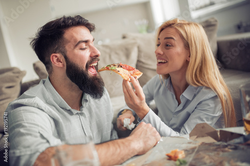 Couple eating pizza snack at home