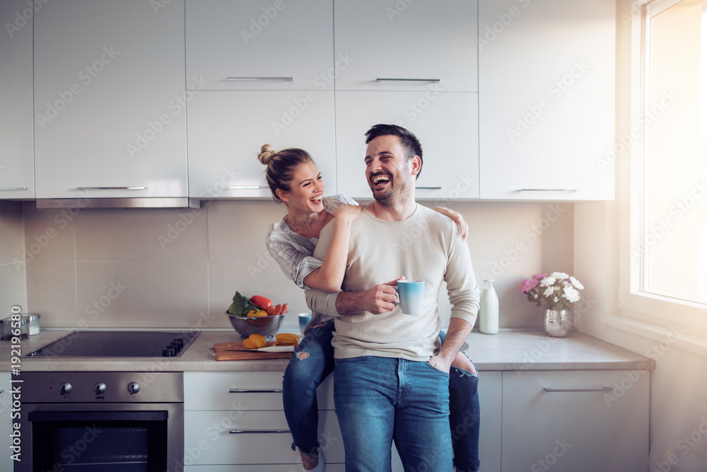 Romantic young couple cooking together in the kitchen - obrazy, fototapety, plakaty 