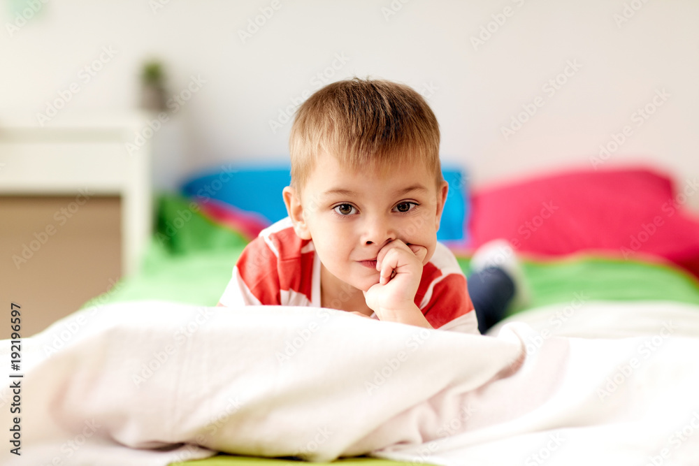 portrait of little boy lying on bed at home portrait of little boy lying on bed at home