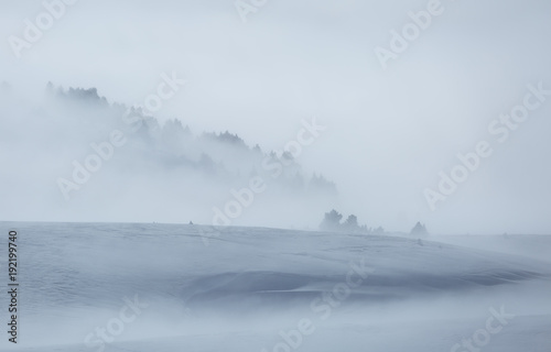 Clouds and fog over a snow covered plateau in the mountains. Vercors, France.