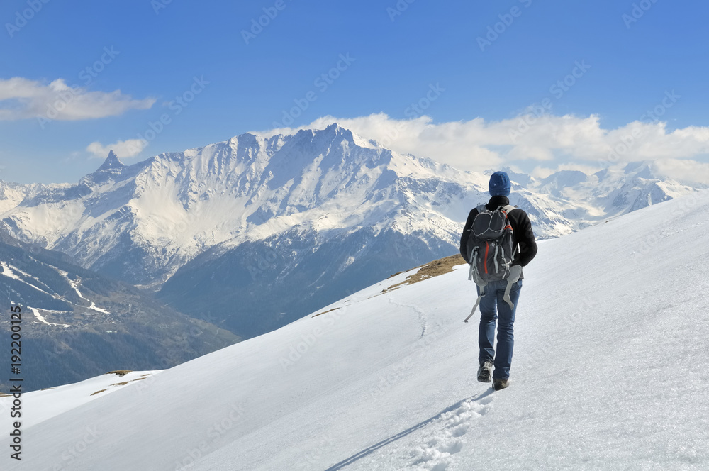 hiker walking on the snow in a beautiful alpine mountain 