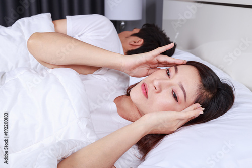 woman having sleepless on bed and having migraine,stress, insomnia, hangover in bedroom