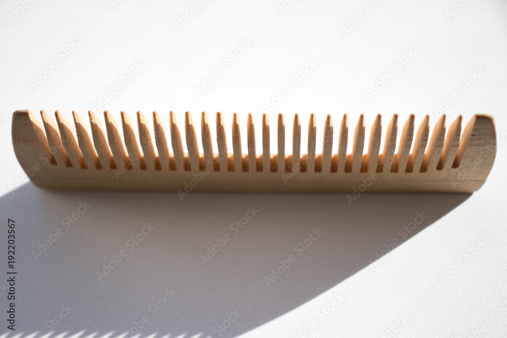 Thin comb of light wood on a white background
