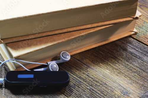 mp3 player and headphones. books. on a wooden table.  Audiobook concept. photo