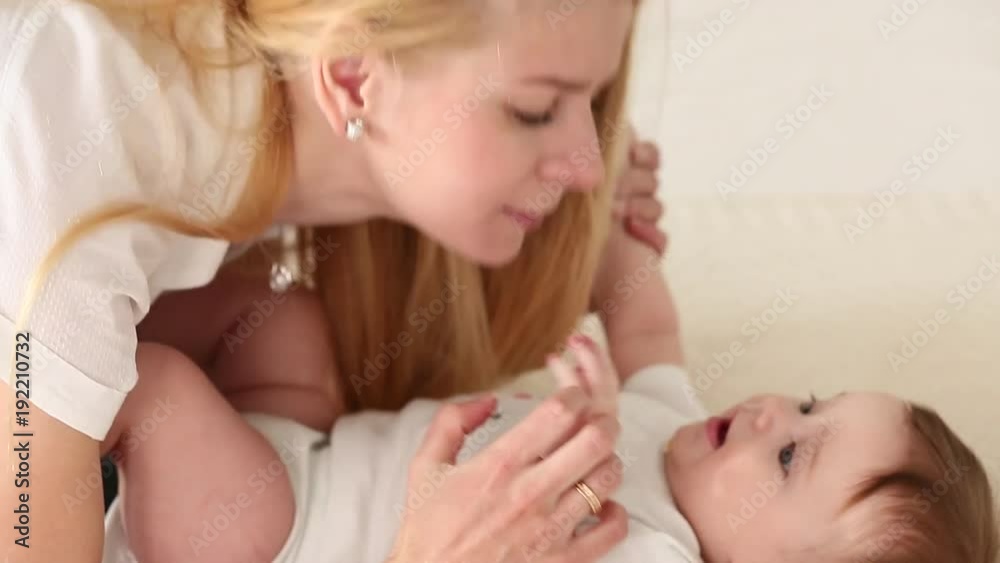 Family, baby and parenthood concept. Happy smiling young mother with infant babygirl at home spend time together Family, baby and parenthood concept. Happy smiling young mother with infant babygirl at home spend time together