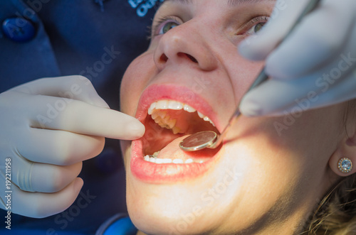 Great concept of dental procedure  young blond Brazilian woman in dental chair suffering dental procedure by dentist.