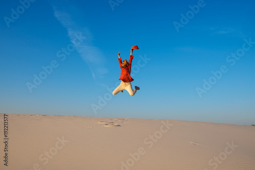 Expressive young woman jumps on the desert
