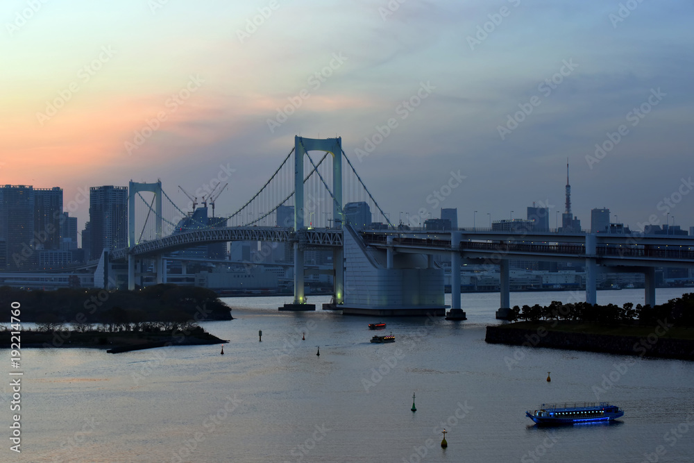 Fototapeta premium Tokyo, Japan - April 16, 2017 : View of Tokyo Bay, Rainbow bridge and Tokyo Tower landmark, sunset scene, Odaiba city on April 16, 2017 at Tokyo Japan