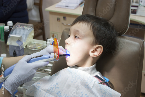 Dentist is treating a boy s teeth