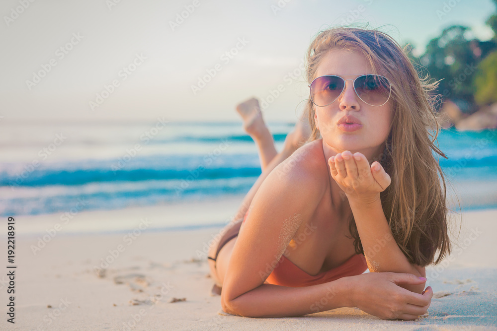 pretty long haired woman blowing air kiss on tropical beach. Mahe, Seychelles