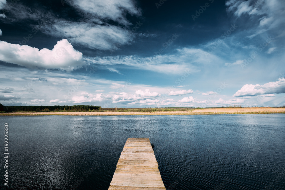 Old Wooden Boards Pier On Calm Water Of Lake Or River At Evening