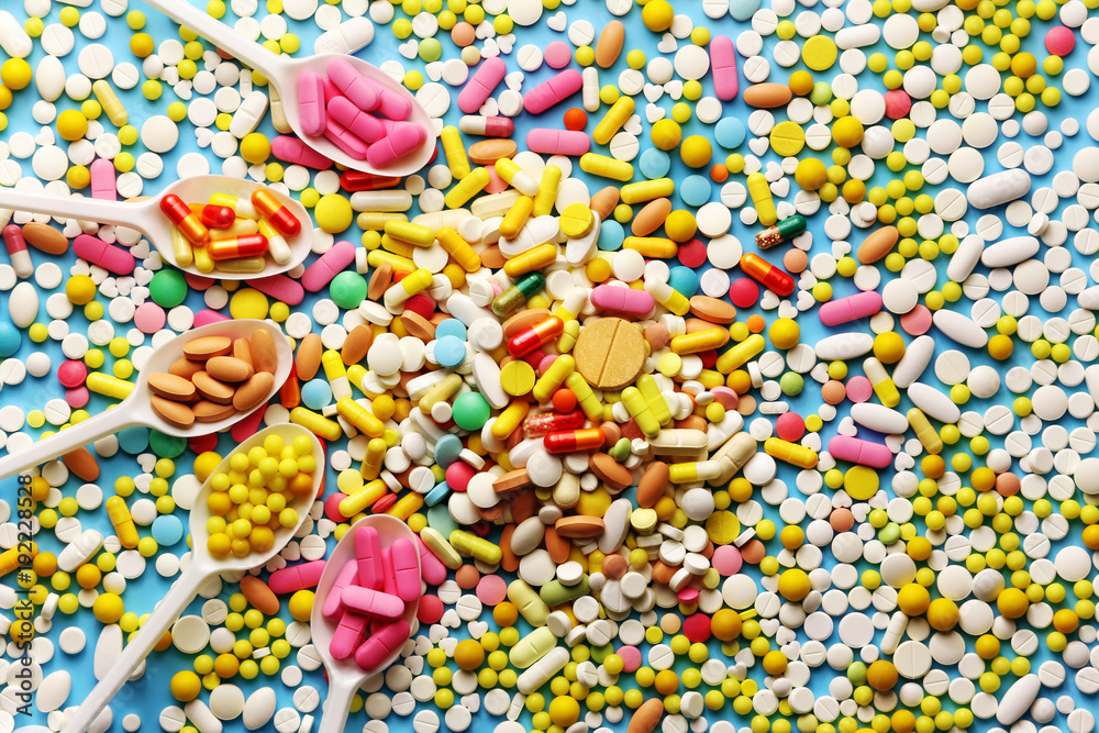 Fototapeta premium Colorful pills on a blue background