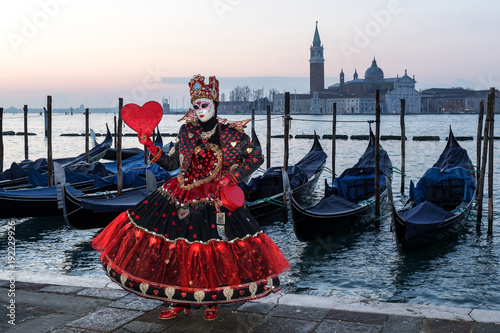 Wonderful costume in black and red with red heart in front of San Giorgio Maggiore, Venice, Carnival