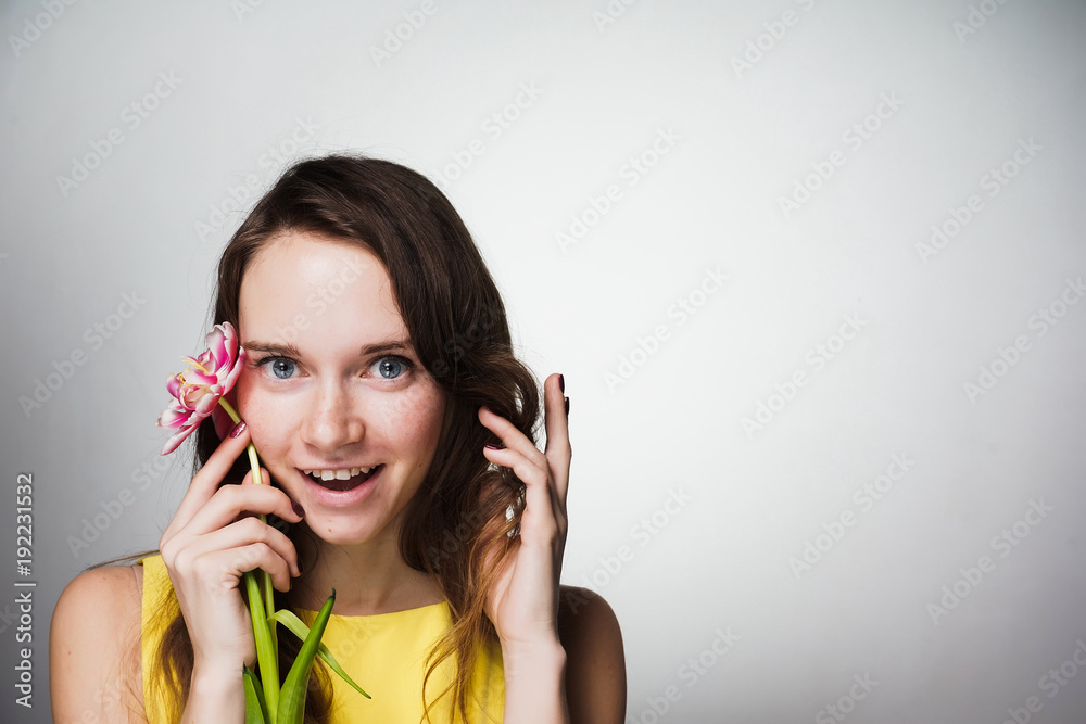 happy young girl holding a fragrant flower in hands, celebrating mother's day happy young girl holding a fragrant flower in hands, celebrating mother's day