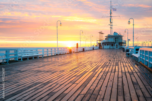 The first rays of the sun warms the wet boards of the pier in Sopot. Poland. photo