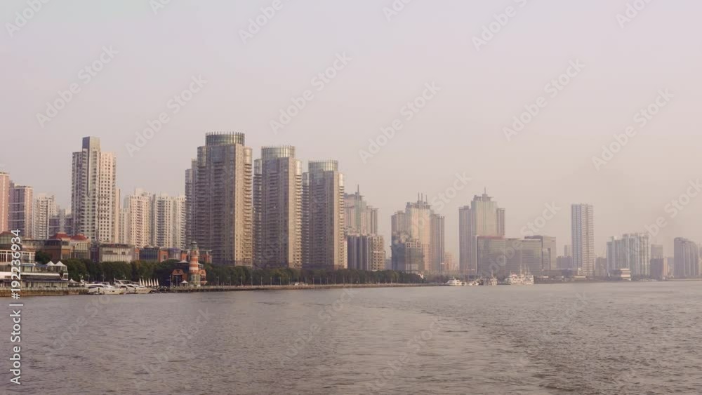 River bank with skyscrapers, landmarks of Shanghai with Huangpu river at sunrise/sunset in China. River bank with skyscrapers, landmarks of Shanghai with Huangpu river at sunrise/sunset in China.