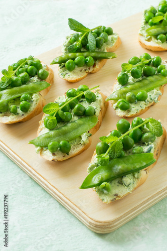 Fresh spring toast with cottage cheese and herbs, green peas and mint sprouts