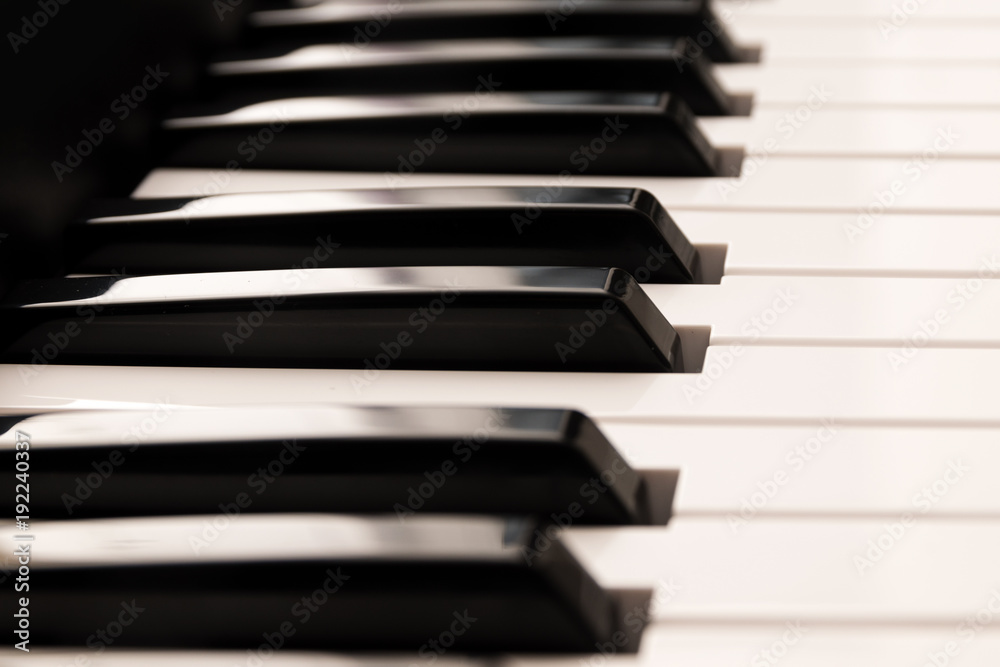 Classic grand piano keyboard, close up of the glossy black and white keys from the side, music background Classic grand piano keyboard, close up of the glossy black and white keys from the side, music background