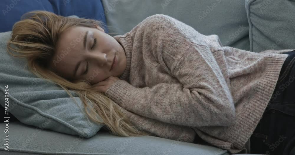 Young sleepy woman falling down on sofa at home. Young sleepy woman falling down on sofa at home.