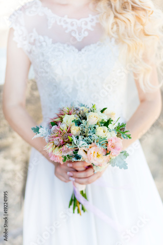 A wedding bouquet in the hand. A bouquet of flowers as a symbol of love is held by a couple in love during the wedding