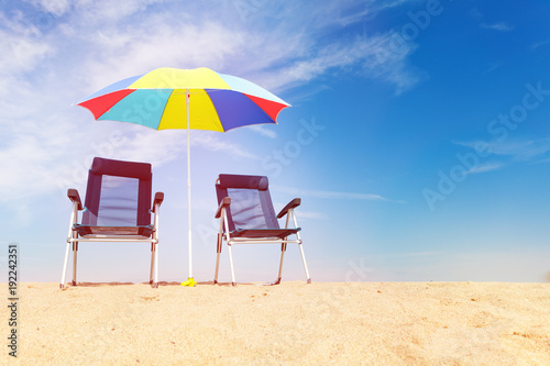 Deck chairs and sun umbrella on the tropical beach