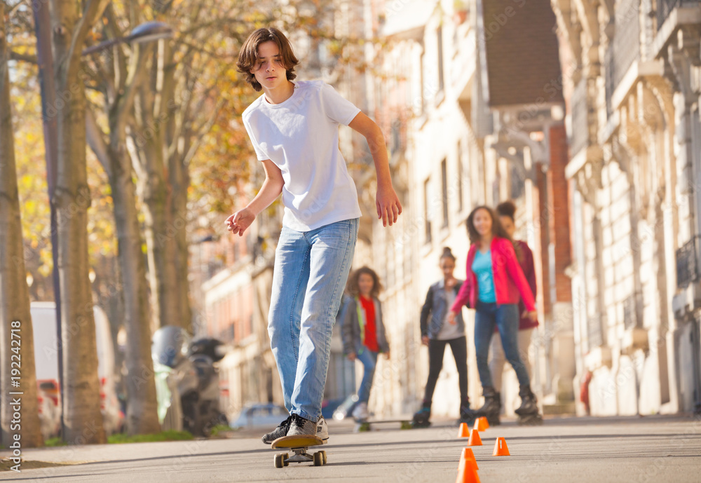 Teenage boy skateboarding at city side walk