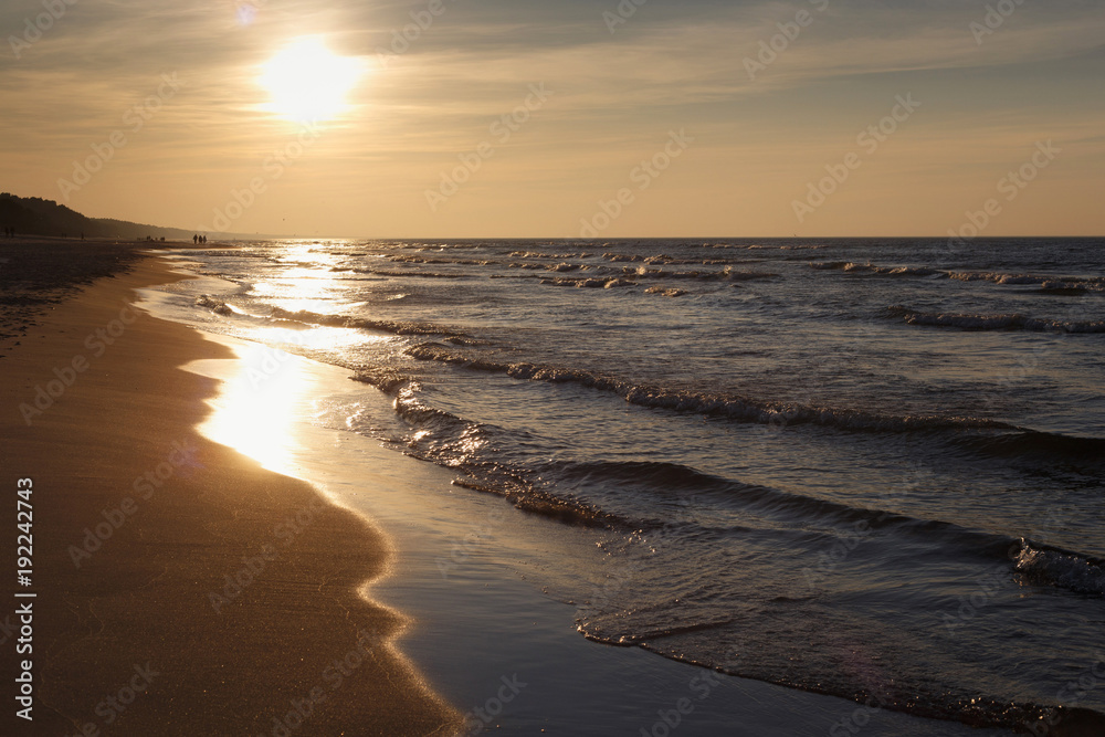 Beautiful sunset seascape on the with sun and small waves.