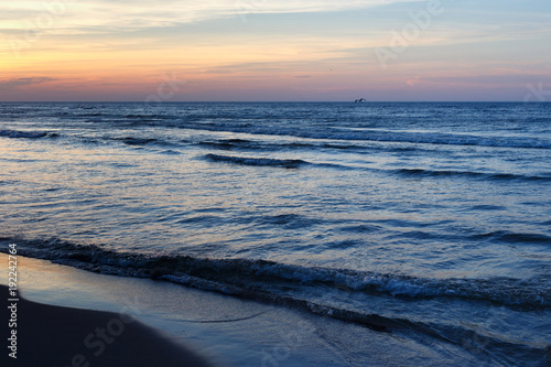 Beautiful sunset seascape with blue water and small waves.