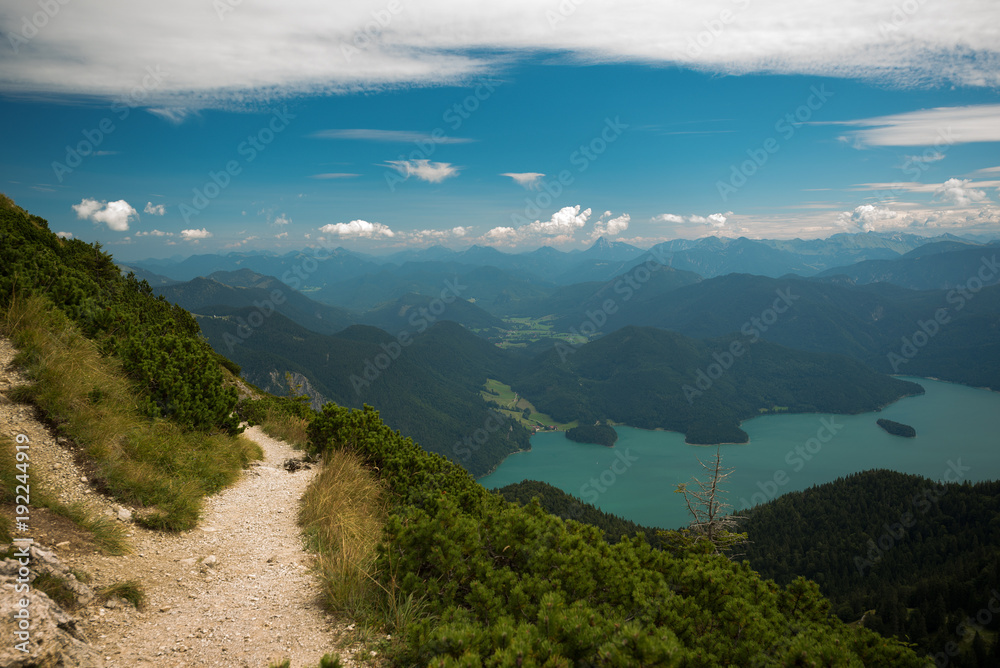 Pathway in mountains against scenic view with lake