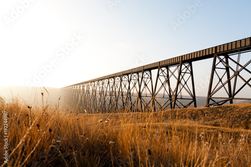 Steel train bridge on a prairie field photo