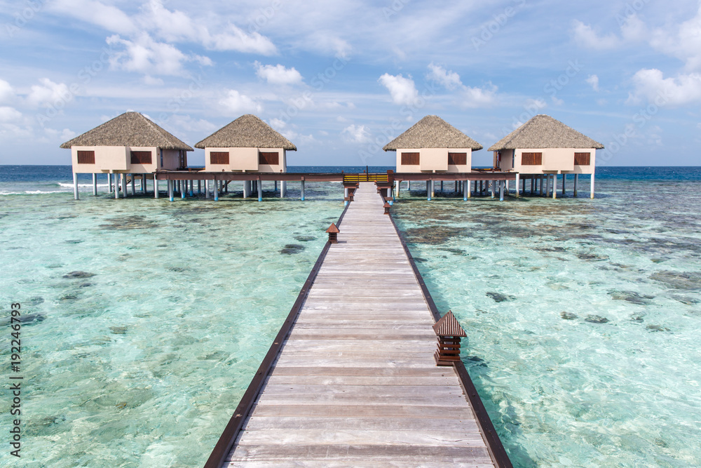 Water villas on crystal clear water at tropical island