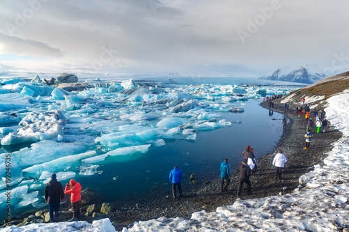 South Iceland - March 12, 2017. Tourist walking along glacier lagoon, Jokulsarlon