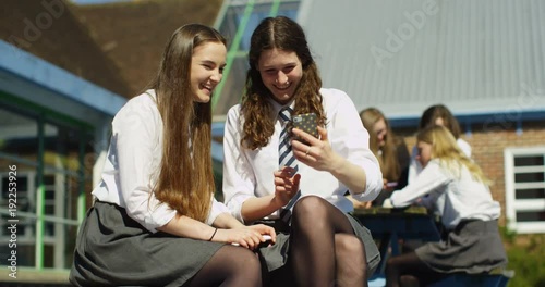 4k, Happy students in school uniforms using smartphone in school. SLow motion.