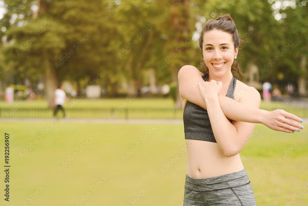 Young woman stretching arms before exercise