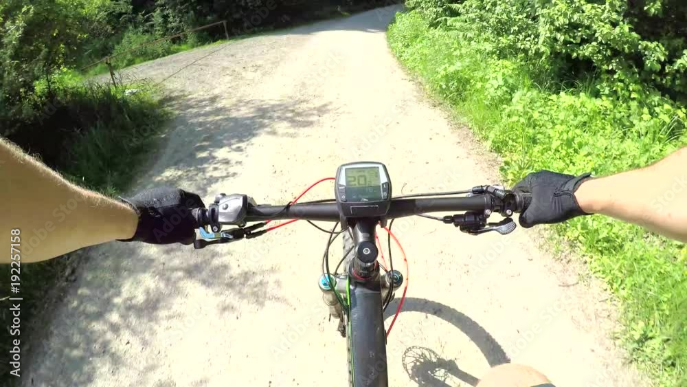POV: Extreme biker cycling down a forest path on a e-bike. Electric bike rider enjoying the outdoors on a warm sunny day. Unrecognizable male cyclist exercising on his ebike riding on a gravel trail. POV: Extreme biker cycling down a forest path on a e-bike. Electric bike rider enjoying the outdoors on a warm sunny day. Unrecognizable male cyclist exercising on his ebike riding on a gravel trail.