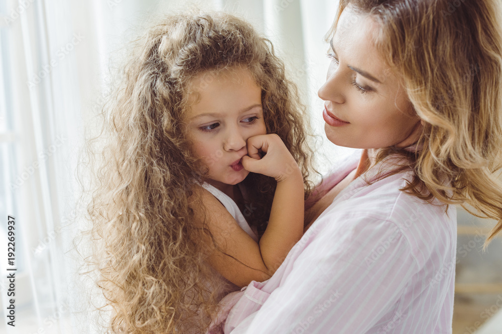 beautiful mother holding on arms her adorable curly daughter beautiful mother holding on arms her adorable curly daughter