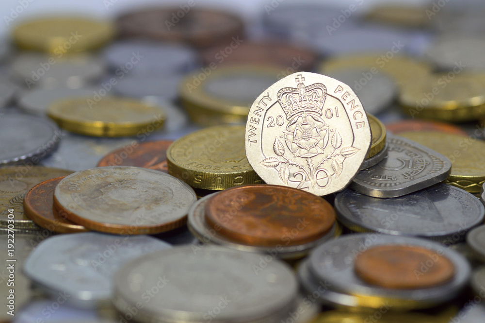 British twenty pence coin on top of a large pile of coins British twenty pence coin on top of a large pile of coins