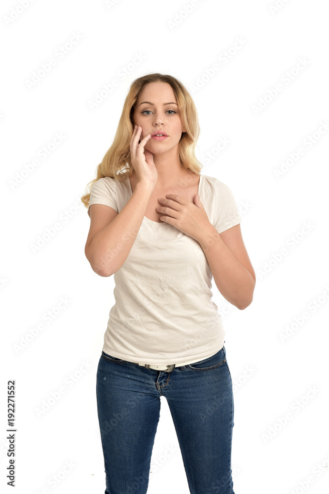 3/4 portrait of blonde girl wearing white shirt, posing with hands touching body. isolated on white background. 3/4 portrait of blonde girl wearing white shirt, posing with hands touching body. isolated on white background.