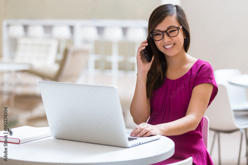 Young career minded entrepreneur working from laptop while talking on the phone