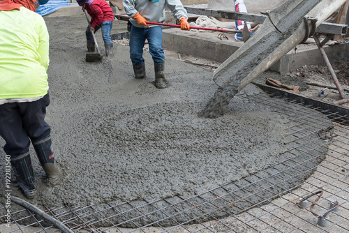 Workers at the construction site placing concrete slab