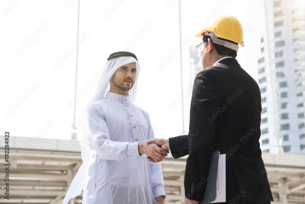 businessman arabic with engineer making handshake agreement. concept finishing up a meeting. businessman arabic with engineer making handshake agreement. concept finishing up a meeting.